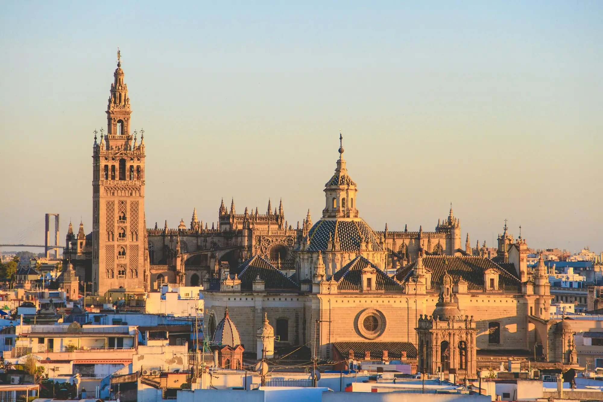 De kathedraal en de Giralda boven de daken van Sevilla bij zonsondergang