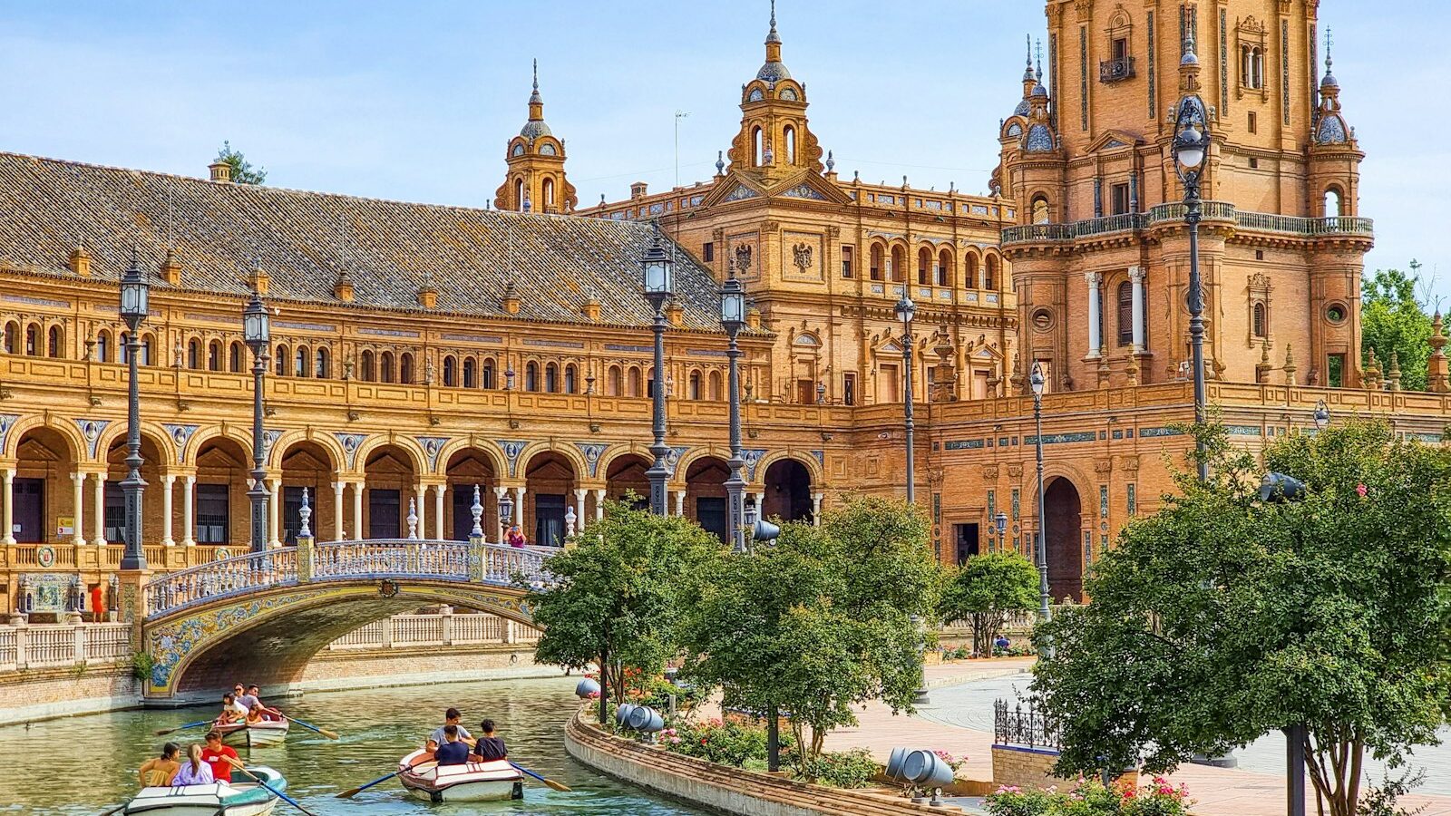 Roeibootjes op het kanaal voor het halfronde gebouw van de Plaza de España in Sevilla